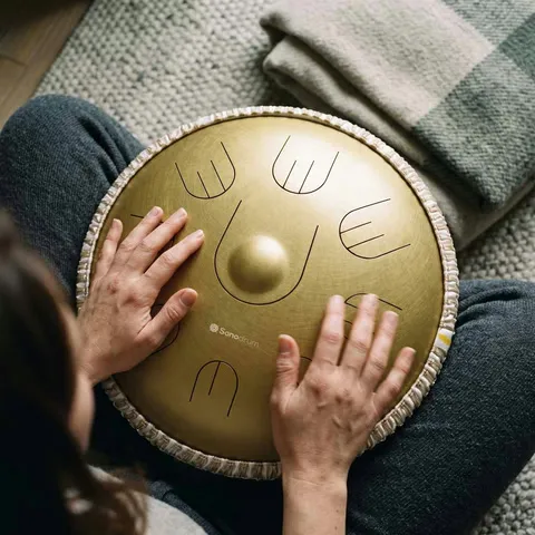 Hände spielen die Sonodrum Handpan Hybrid in Gold, von oben fotografiert